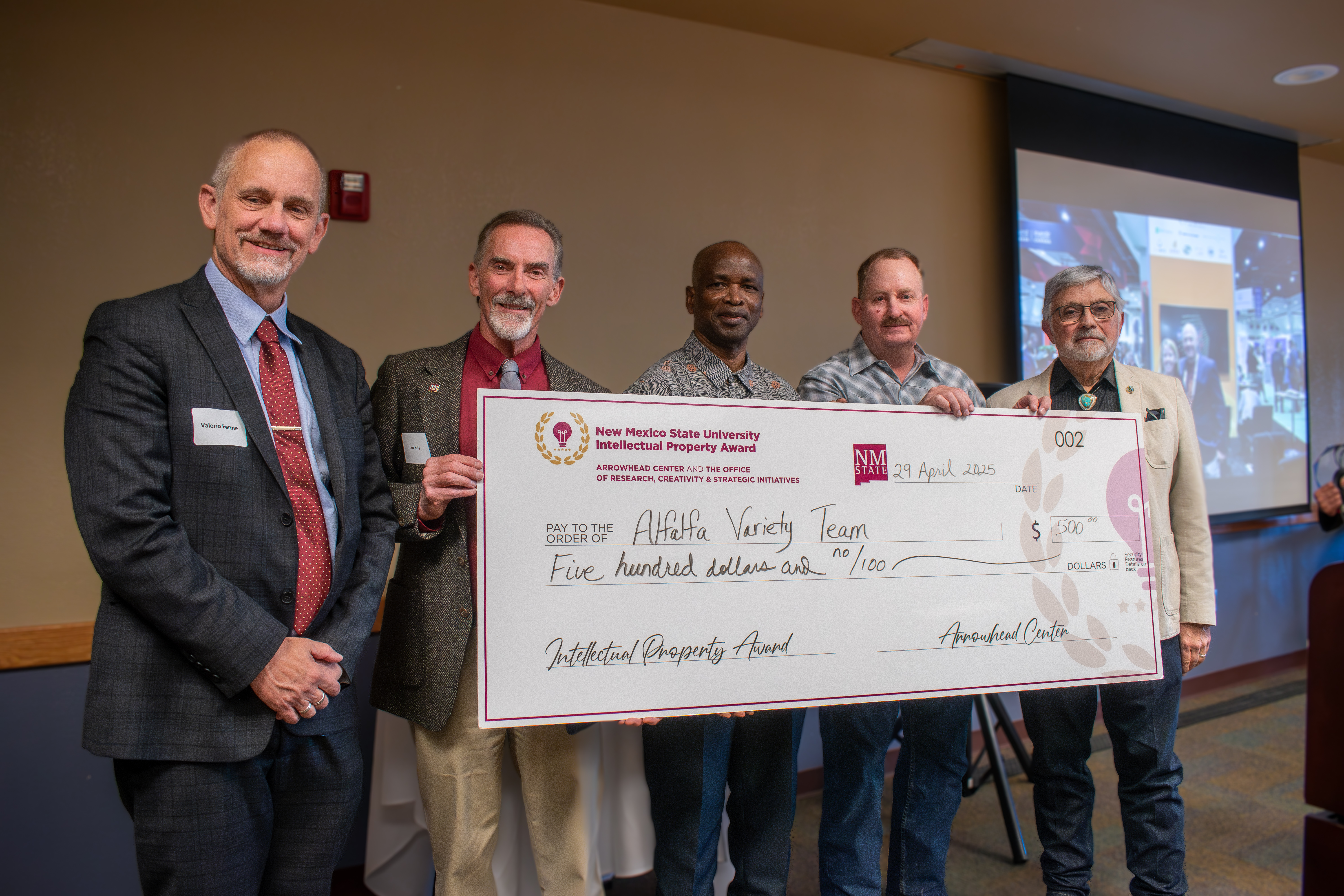 New Mexico State University representatives present a large check to the Alfalfa Variety Team for winning the Intellectual Property Award.